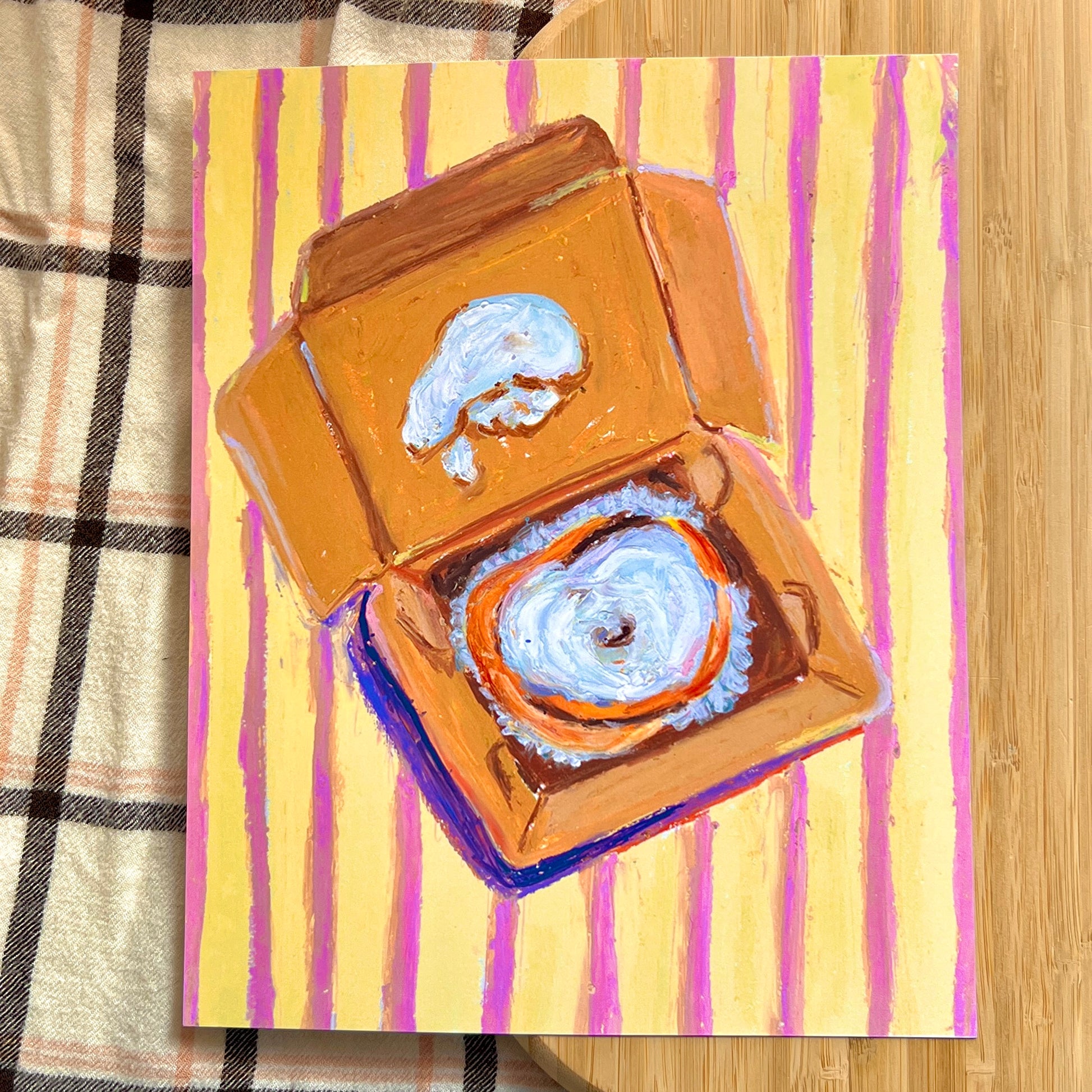 illustrated cinnamon bun packaged on a striped background