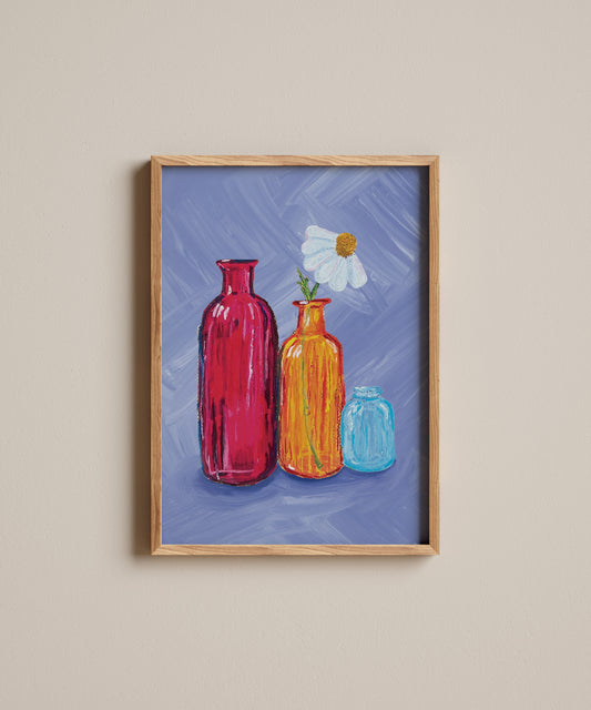 Framed artwork of colorful bottles and a flower on a blue background