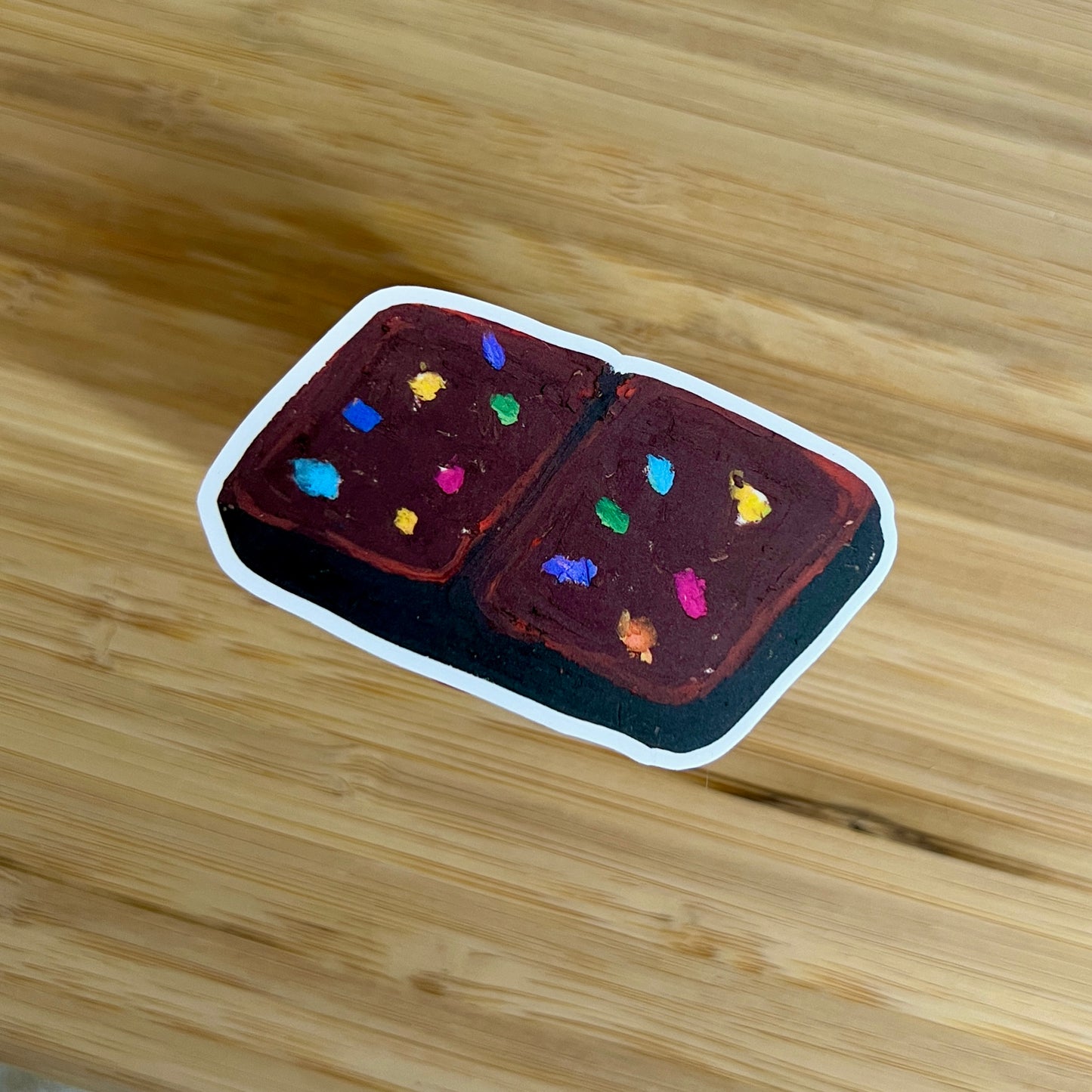 Small brownie with colorful sprinkles on a wooden surface