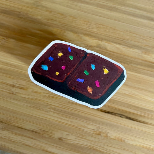Small brownie with colorful sprinkles on a wooden surface
