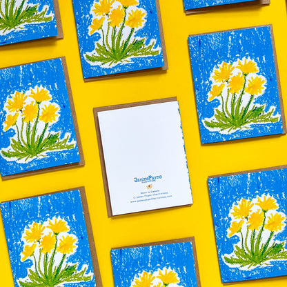 Note cards with floral design on blue backgrounds arranged on a yellow surface, Janine Payne Illustrations brand visible.