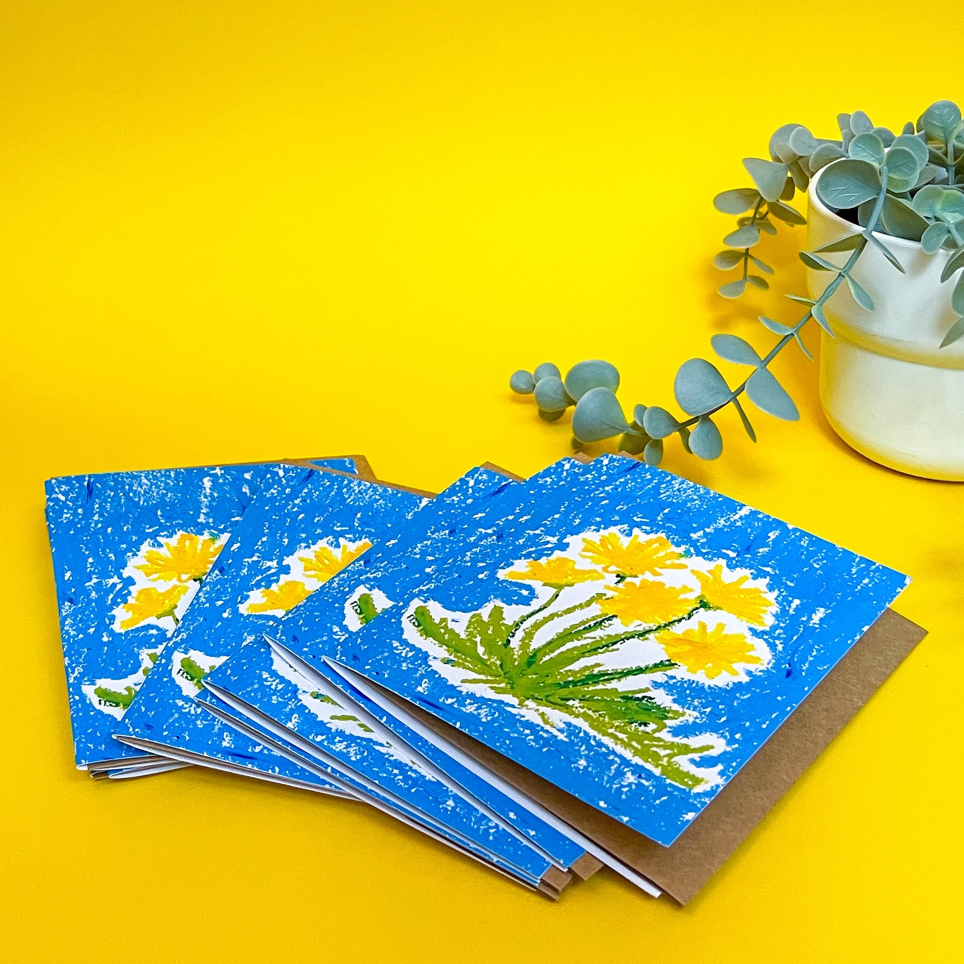 Stack of greeting cards with floral design on a yellow background