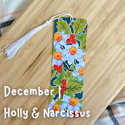 Floral bookmark with tassel on a wooden surface, featuring 'December' and 'Holly & Narcissus'.
