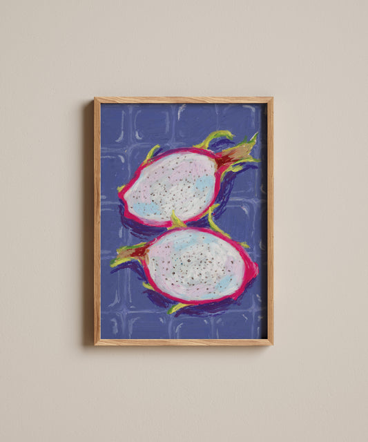 Framed artwork of two dragon fruits on a blue background, mounted on a beige wall.