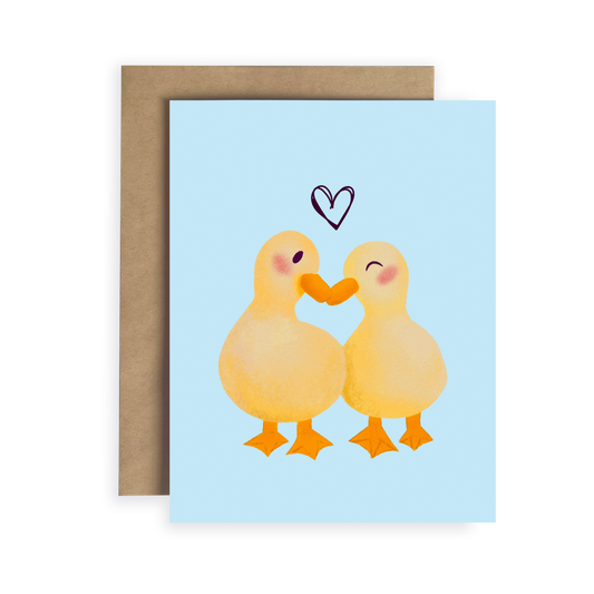Greeting card with two ducks holding hands and a heart above them on a light blue background.