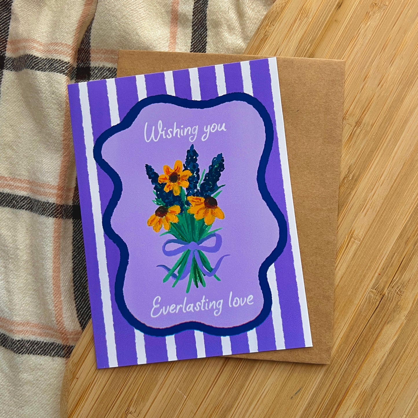 Greeting card with floral design and text on a wooden surface