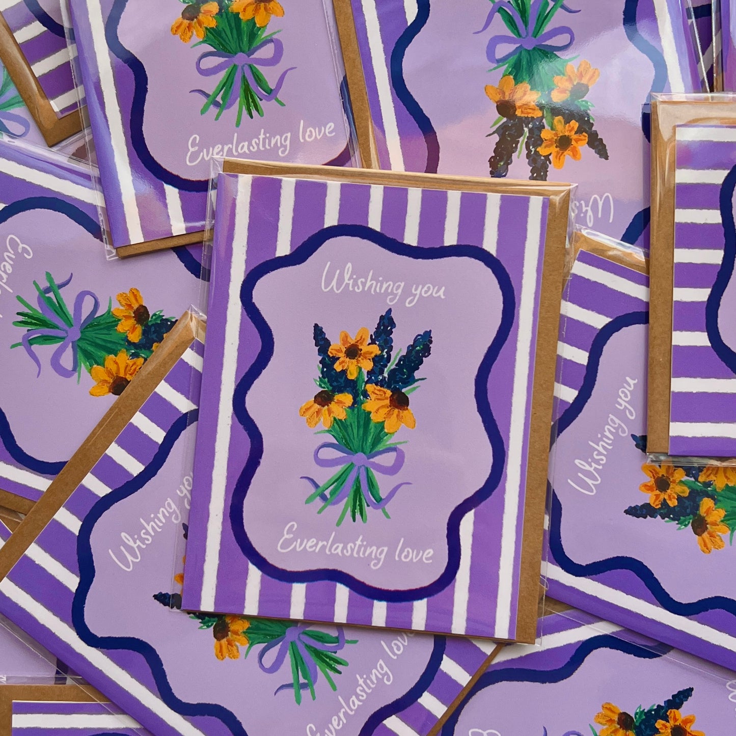 Purple greeting cards with floral designs and text on a matching background