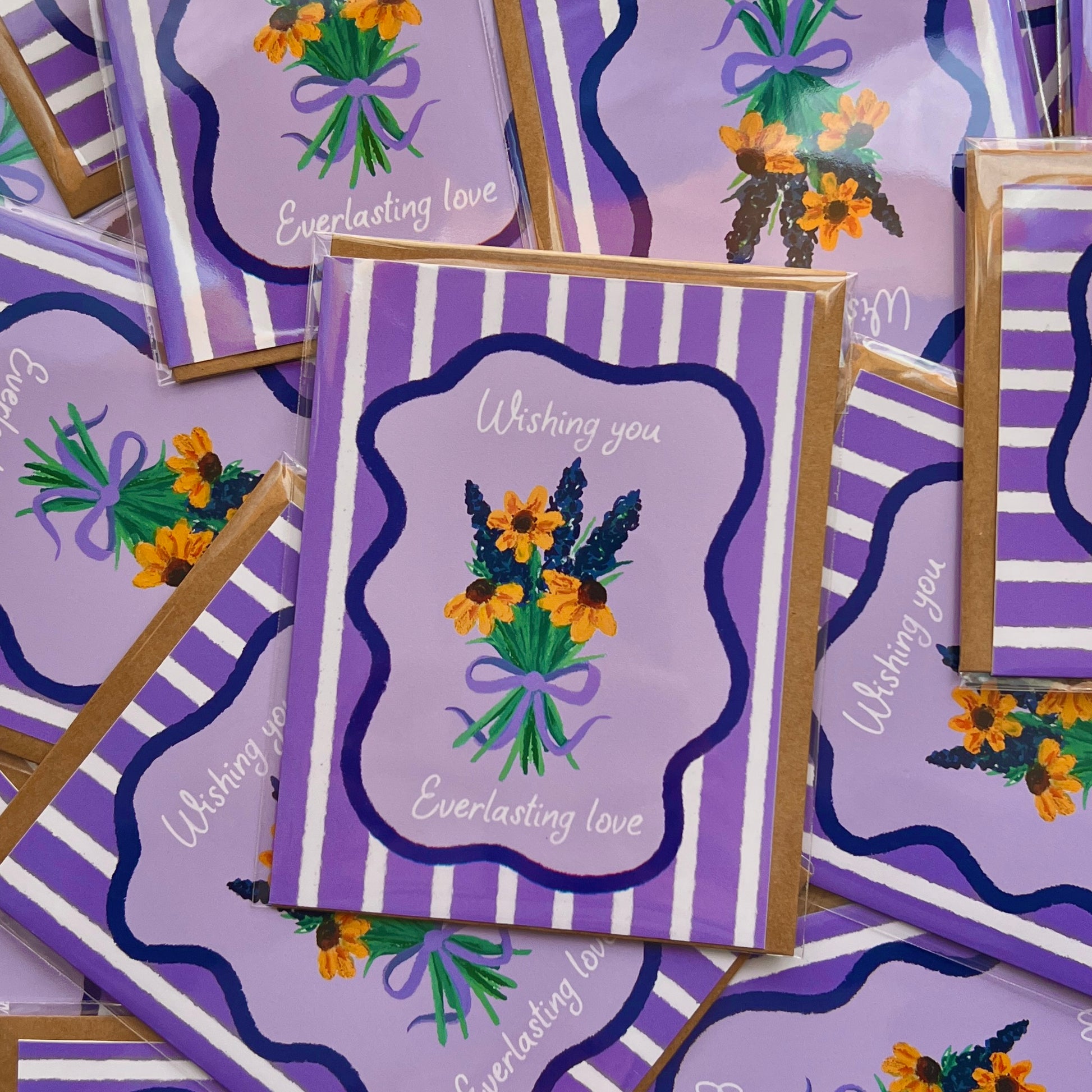 Purple greeting cards with floral designs and text on a matching background