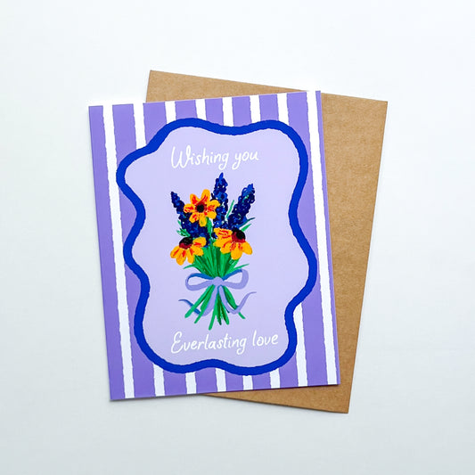 wedding card with hand drawn flowers and text 'wishing you everlasting love' on a purple striped background with Kraft envelope