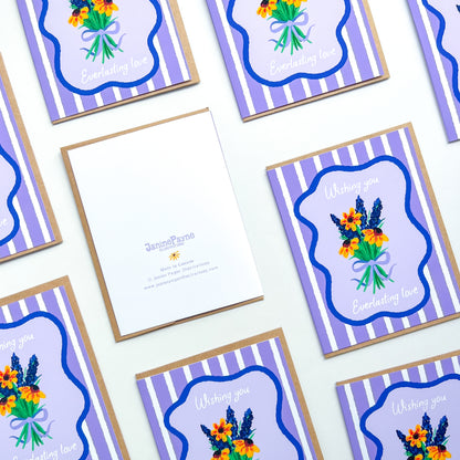 wedding cards with hand drawn flowers and text 'wishing you everlasting love' on a purple striped background with Kraft envelope and Janine Payne illustrations branding 