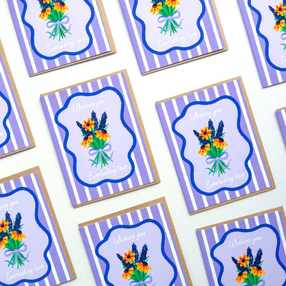 wedding cards with hand drawn flowers and text 'wishing you everlasting love' on a purple striped background with Kraft envelope