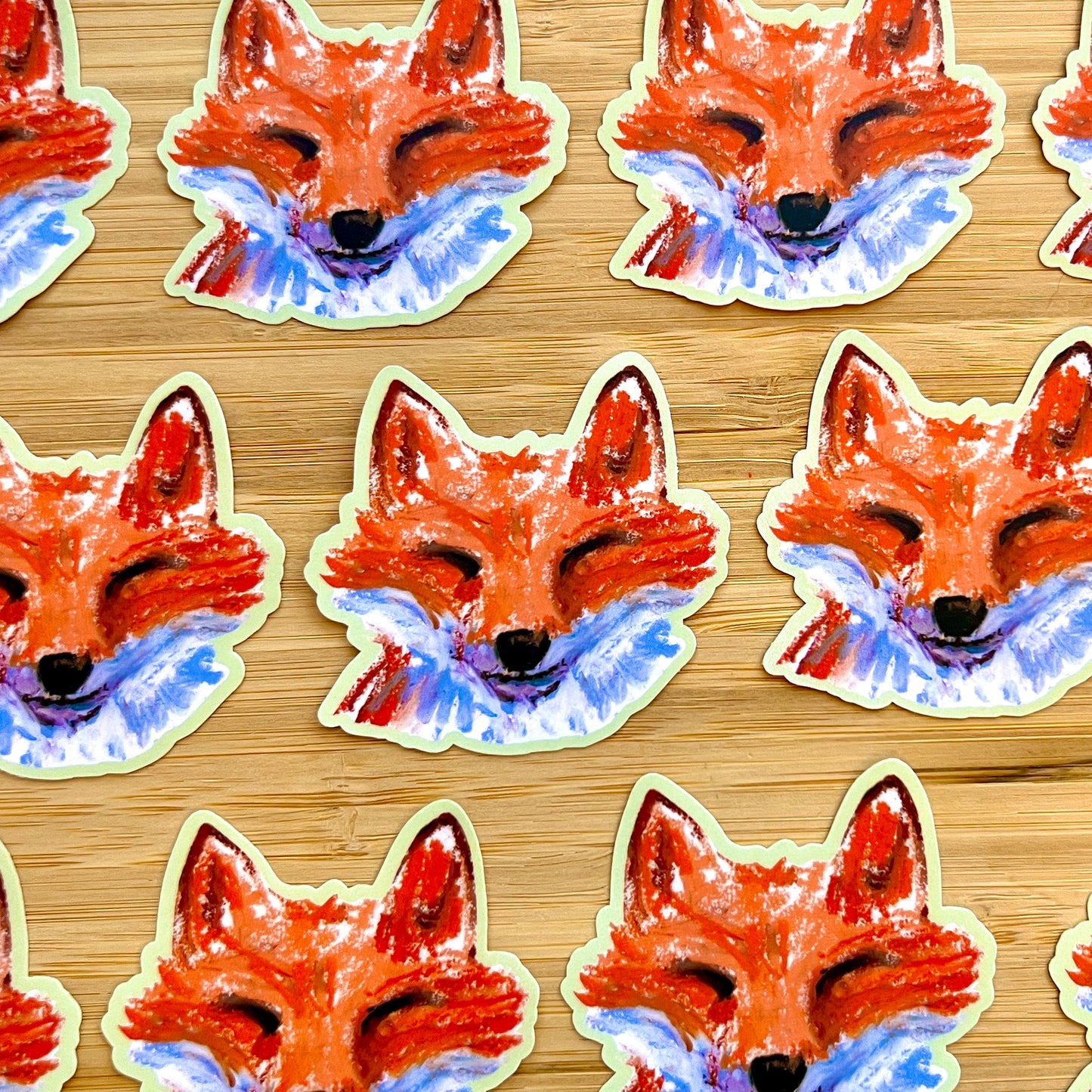 Pattern of fox face stickers on a wooden surface