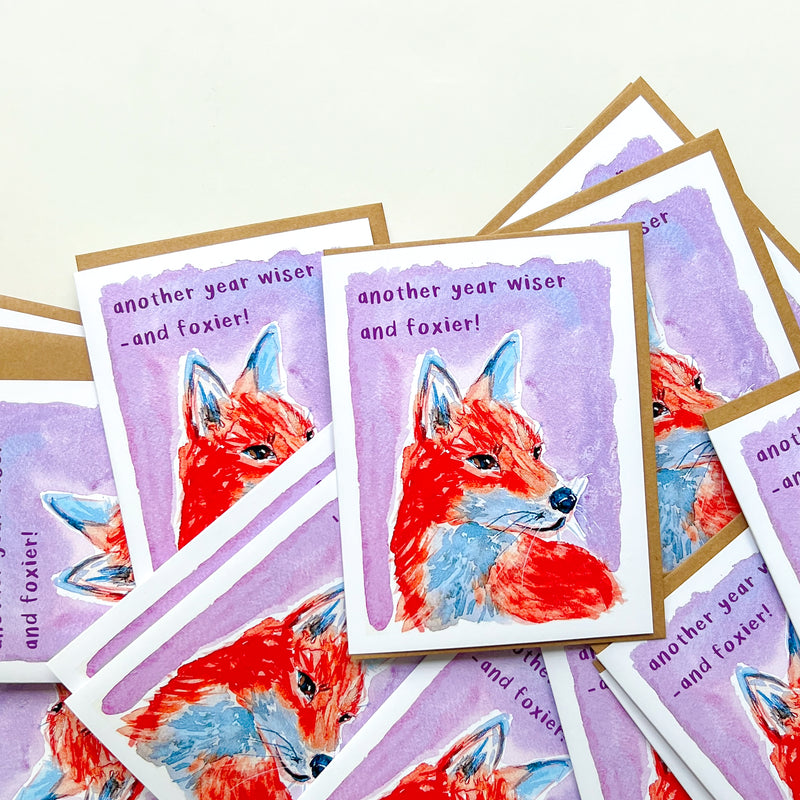 Stack of greeting cards with fox illustration and text on a white background