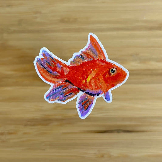 Sticker of a  goldfish on a wooden surface