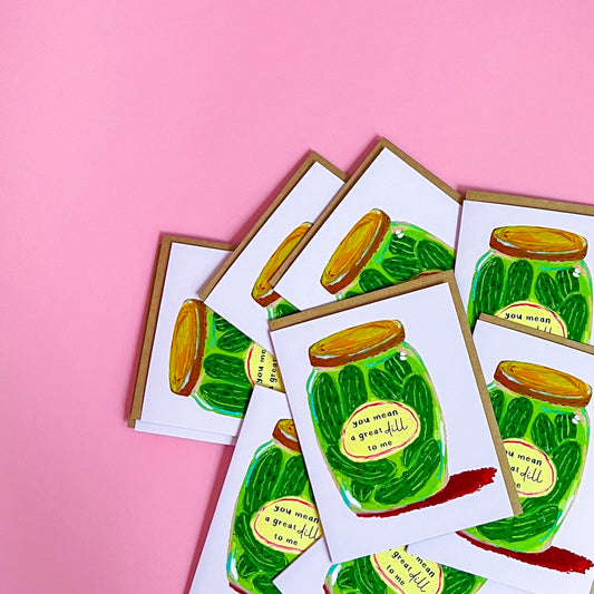 Set of greeting cards with a pickle jar illustration and text 'You Mean A Great Dill To Me' on a pink background