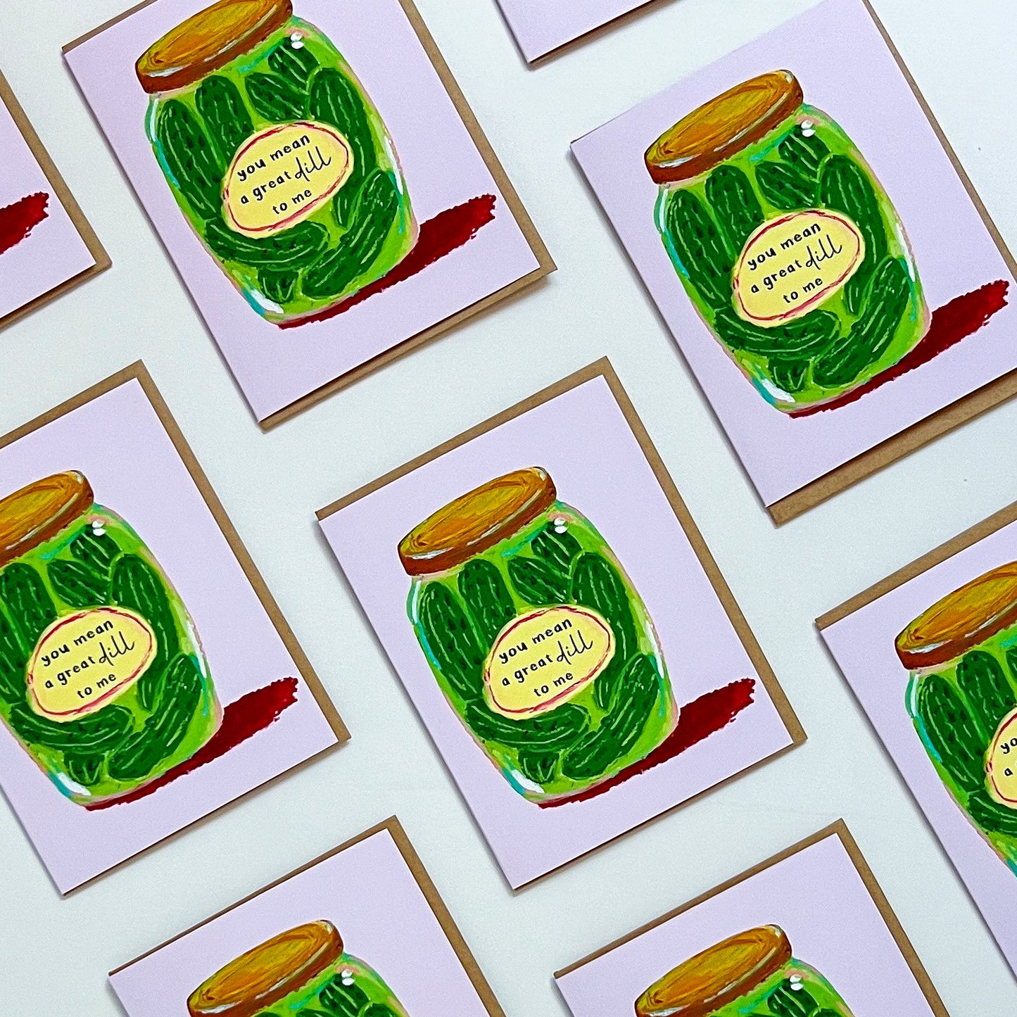 Multiple greeting cards with a green jar of pickles design on a white background