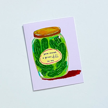 Greeting card with a pickle jar illustration and text 'You Mean A Great Dill To Me' on a white background