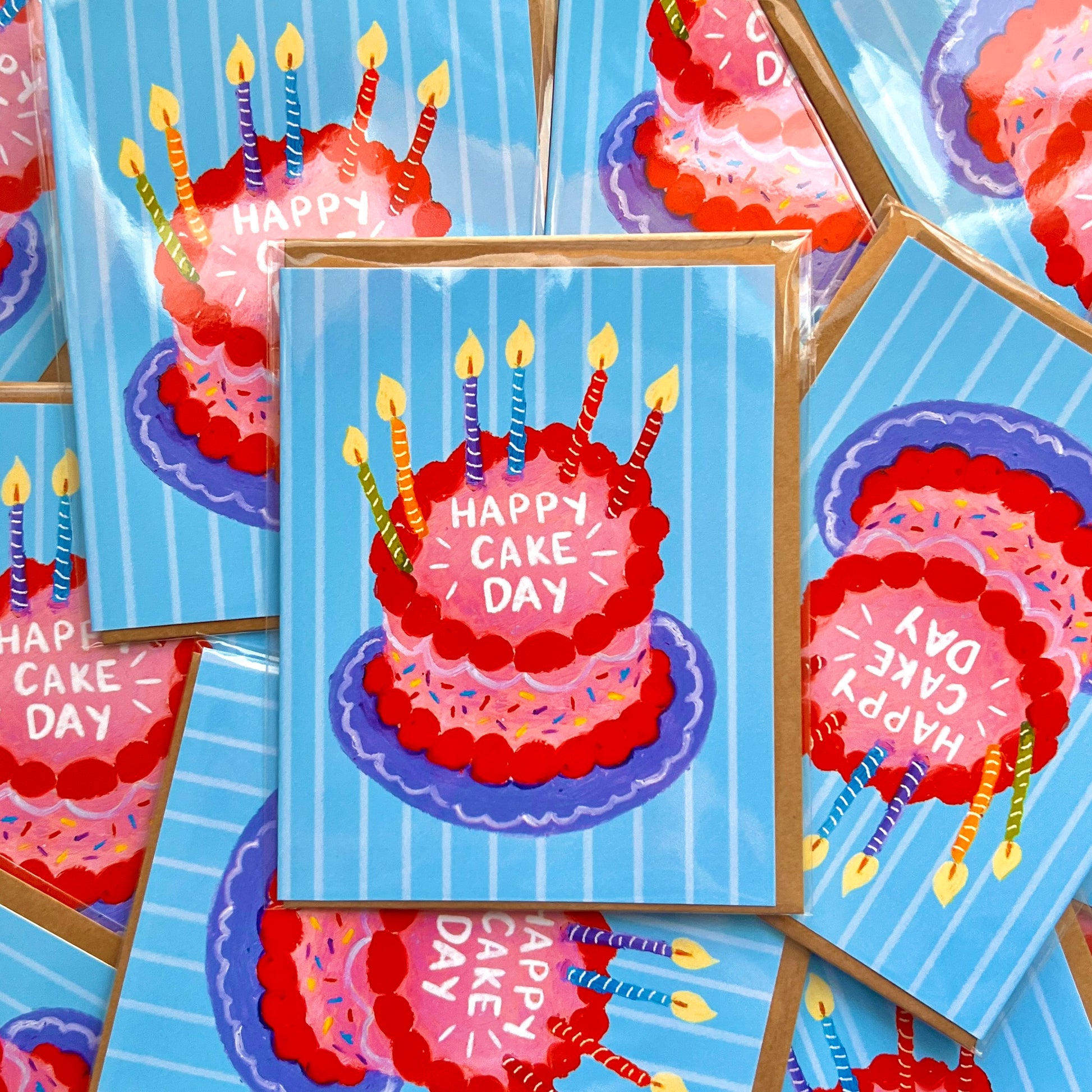 Multiple greeting cards with a red cake illustration and 'Happy Cake Day' text on a blue striped background.