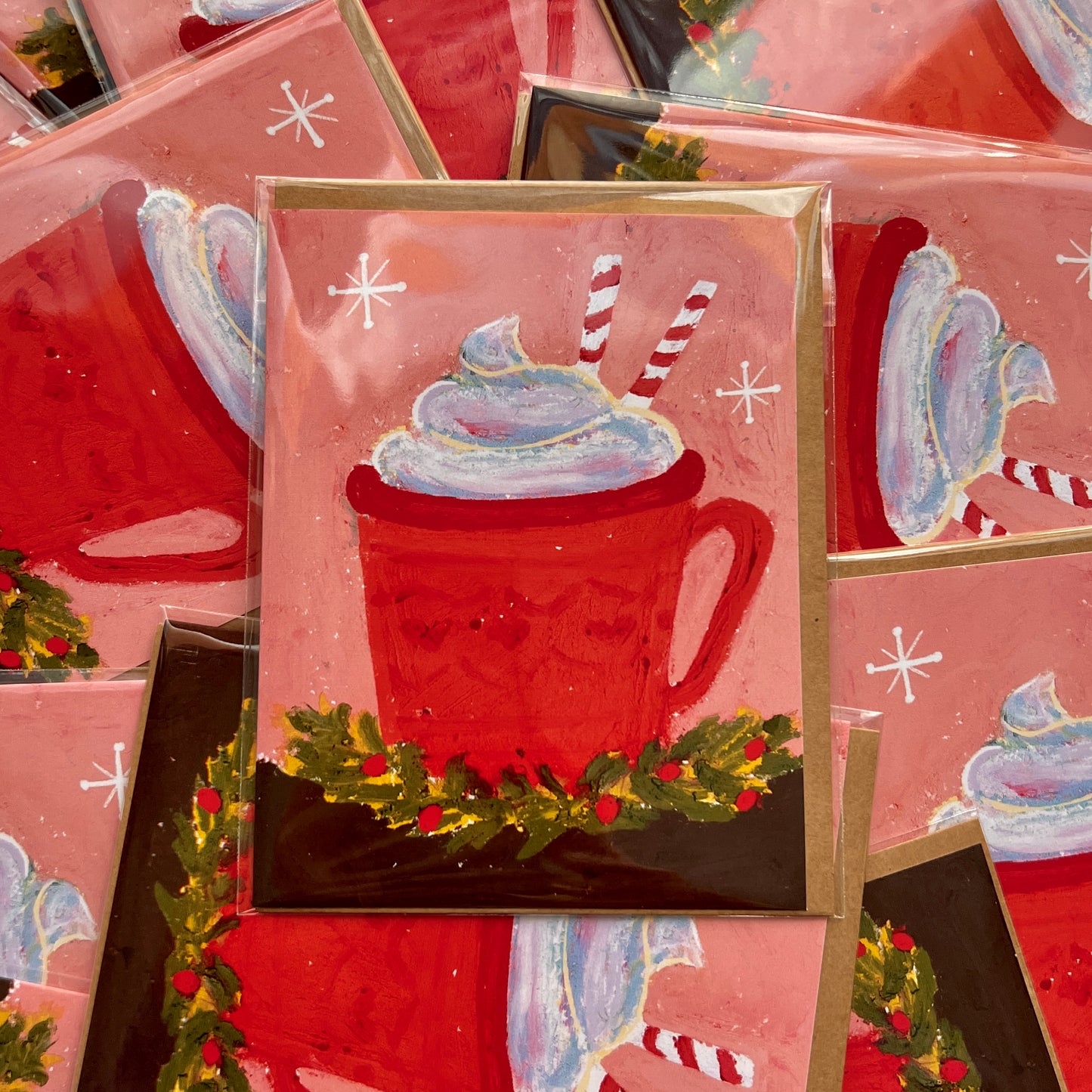Stack of Christmas-themed greeting cards with a red mug and whipped cream design.