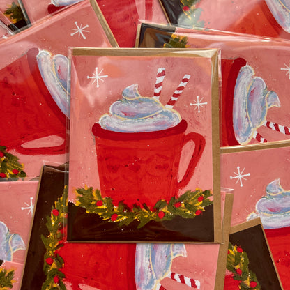 Stack of Christmas-themed greeting cards with a red mug and whipped cream design.