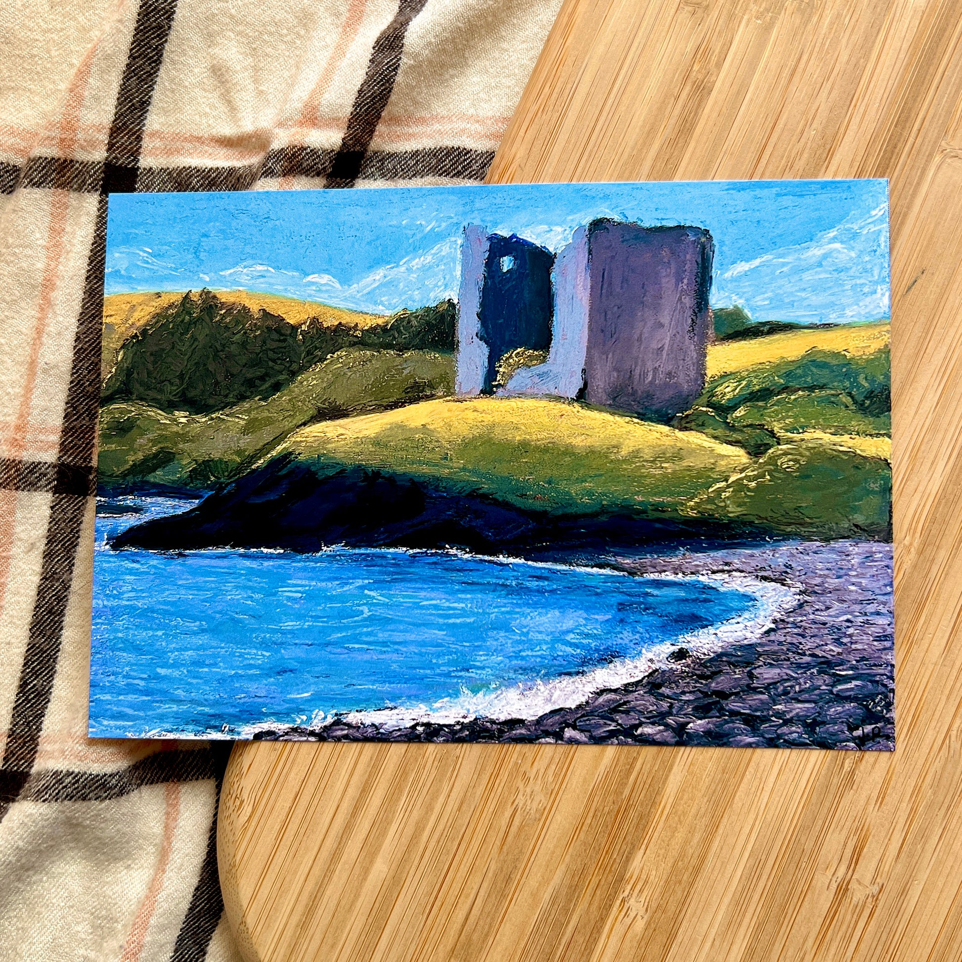 painted landscape of rolling hills and rocky shore