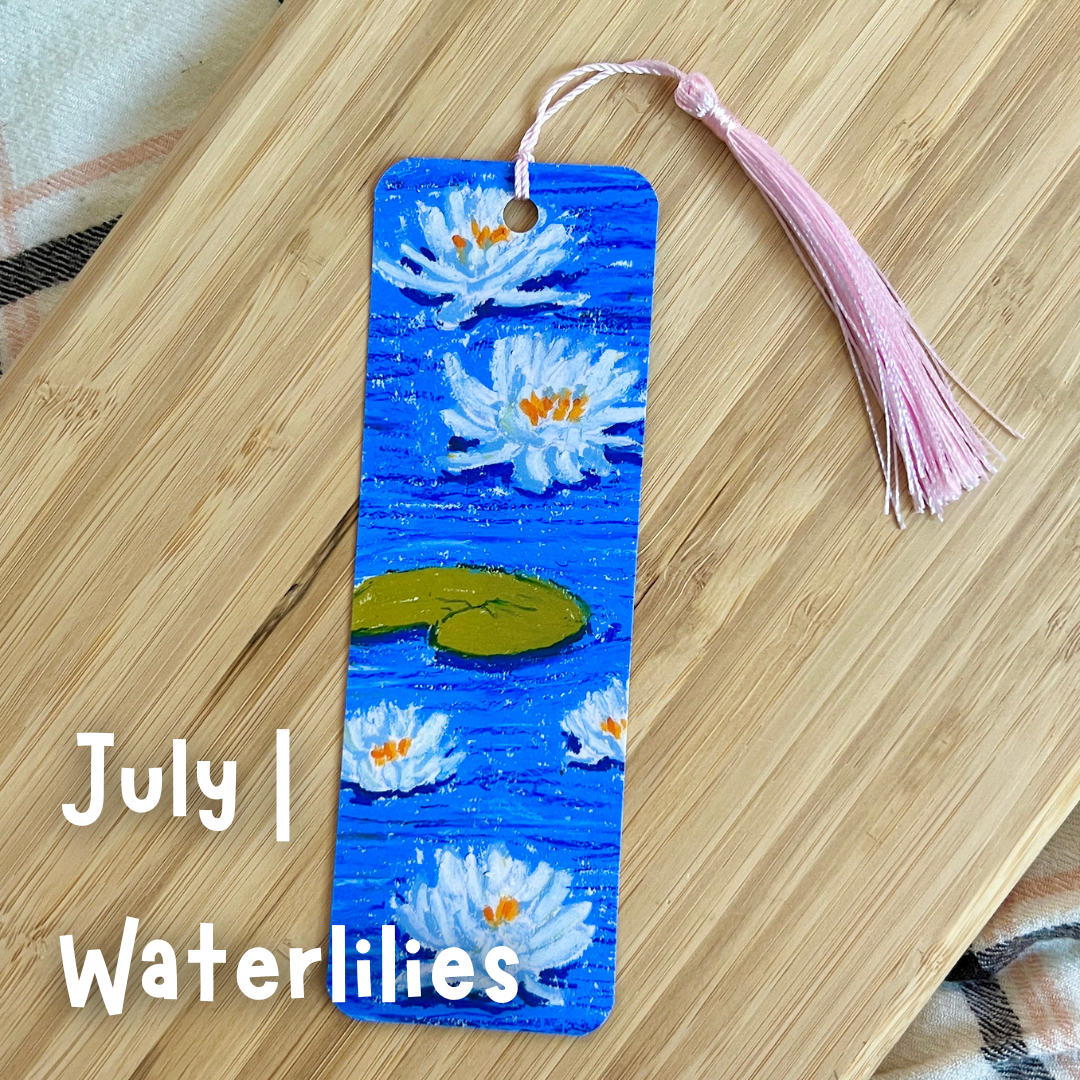 Bookmark with waterlily design on a wooden surface, with text 'July | Waterlilies'