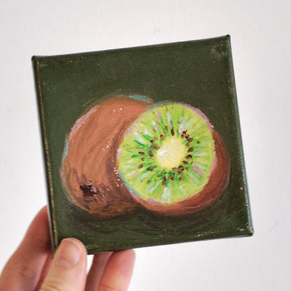 Small square painting of a sliced kiwi on a dark green background
