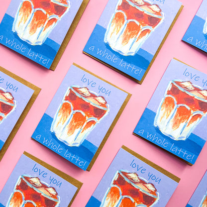 pattern of greeting cards with a drawing of an iced latte and text 'love you a whole latte!' on a pink background