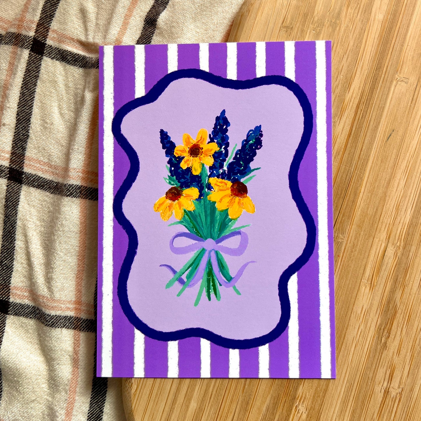 illustrated lavender and sunflowers tied with a bow on a purple striped background