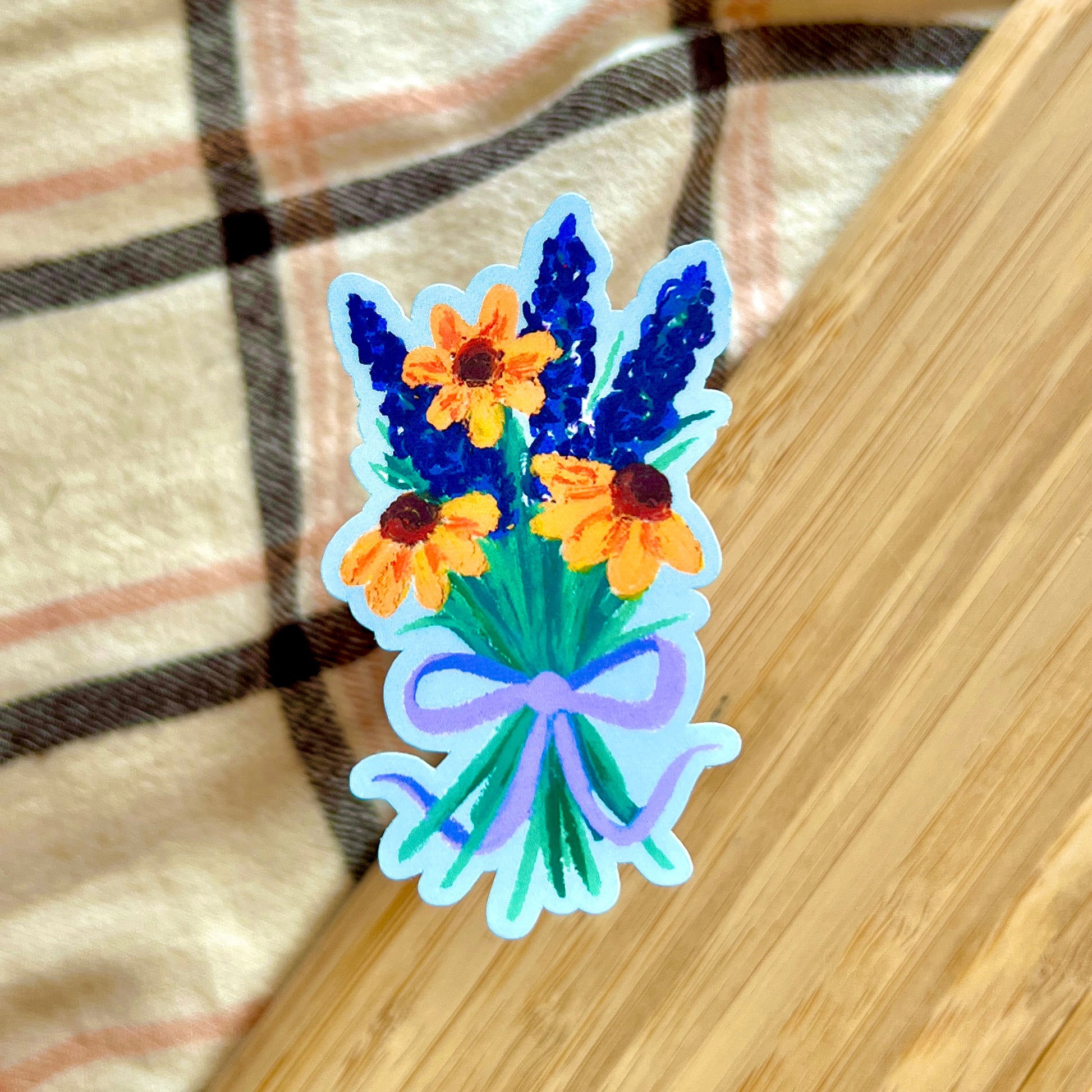 Floral sticker with blue and orange flowers on a wooden surface