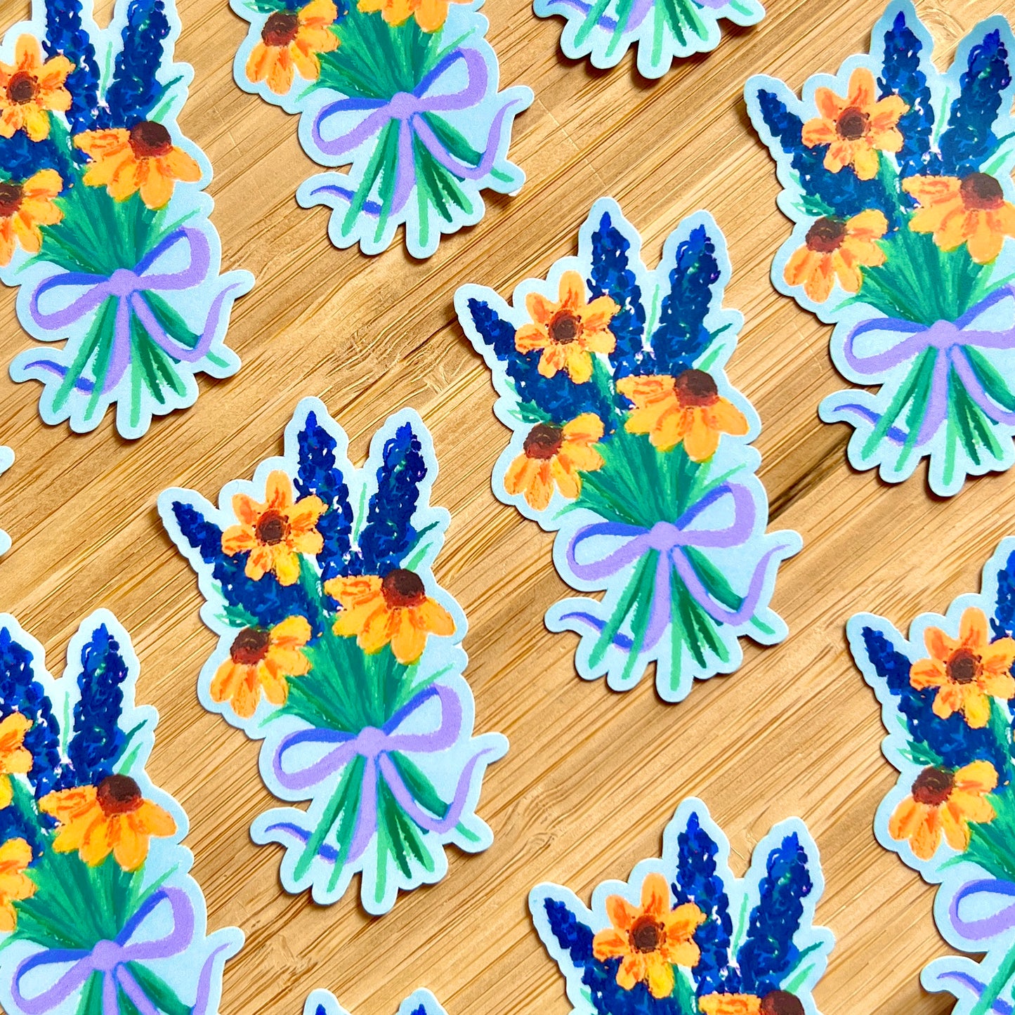 Stickers of floral bouquets with blue and orange flowers on a wooden surface