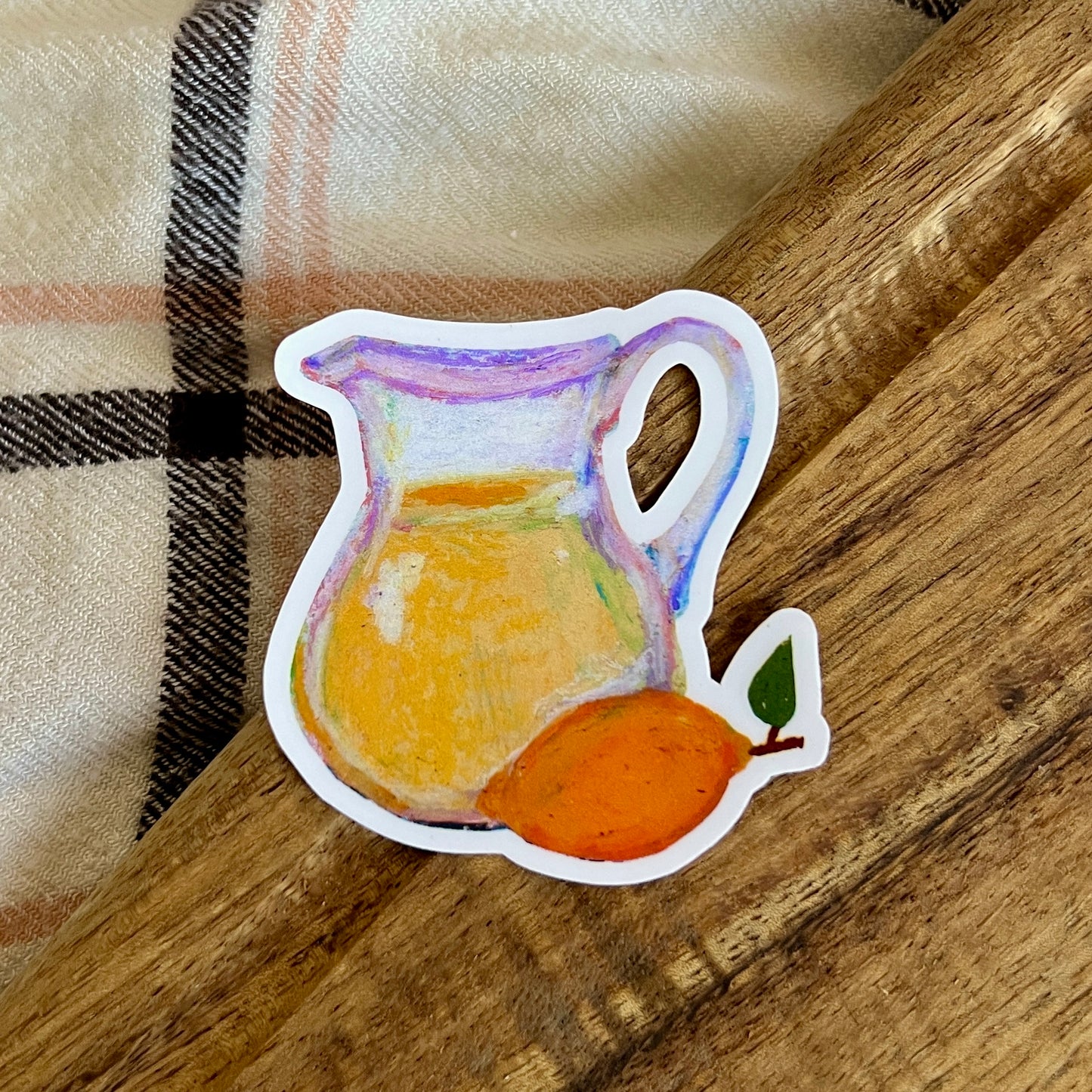 Sticker of a pitcher and lemon on a wooden surface