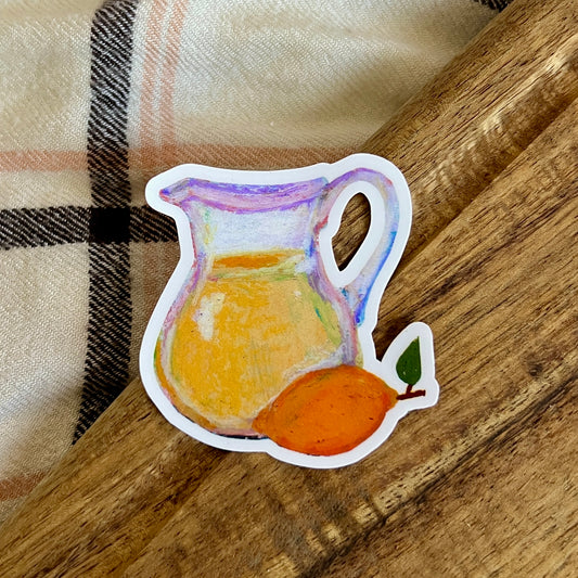 Sticker of a pitcher and lemon on a wooden surface