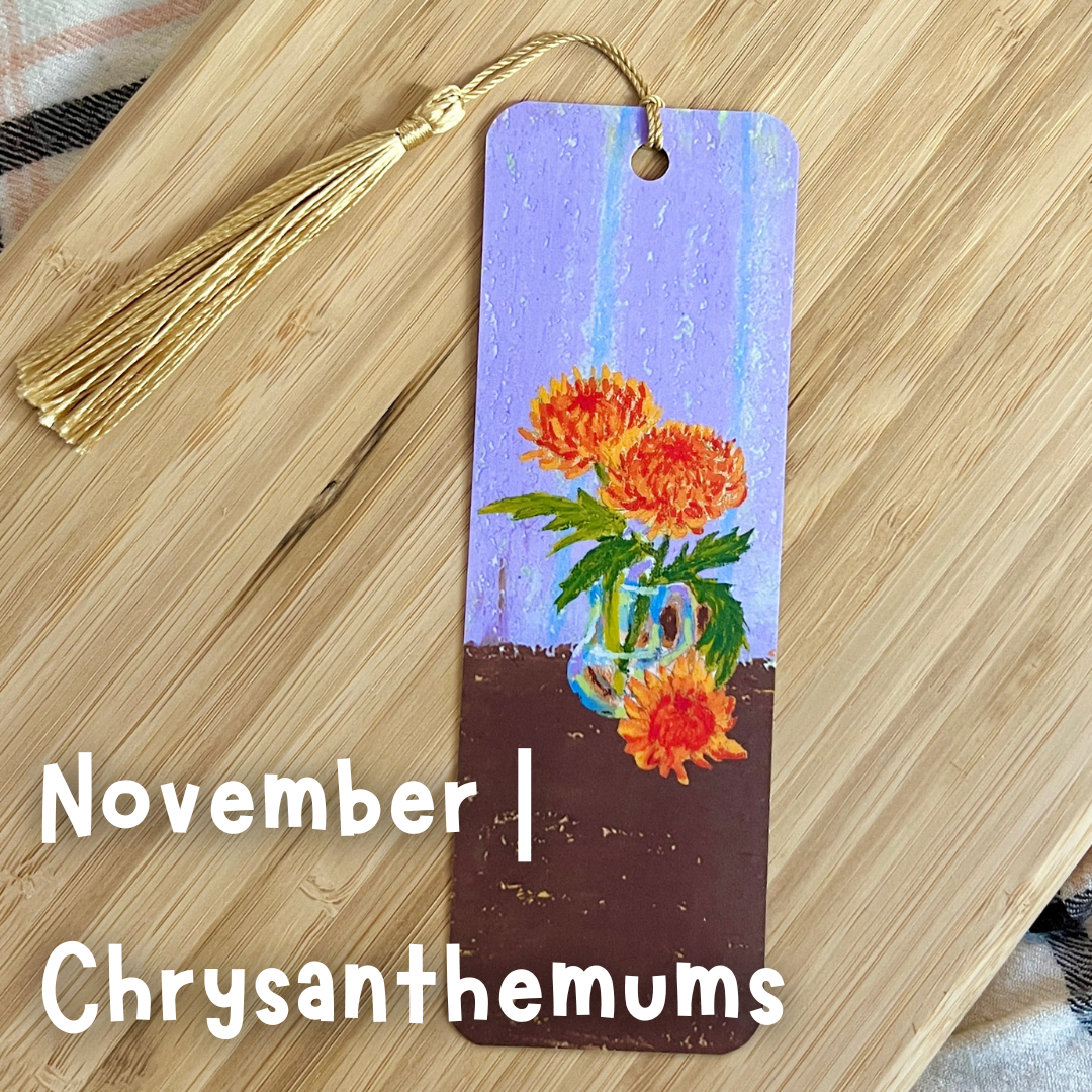 Bookmark with chrysanthemum design on a wooden surface