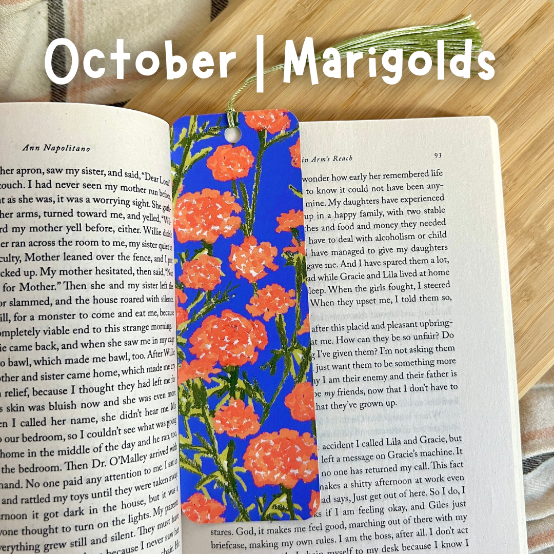 Floral bookmark on an open book with 'October | Marigolds' text