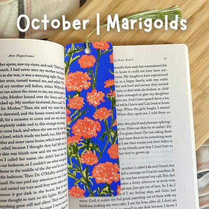 Floral bookmark on an open book with 'October | Marigolds' text