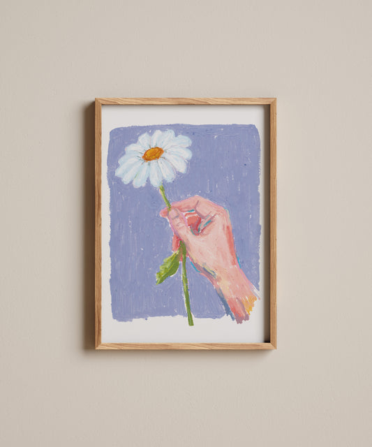 Framed artwork of a hand holding a daisy against a purple background on a beige wall.