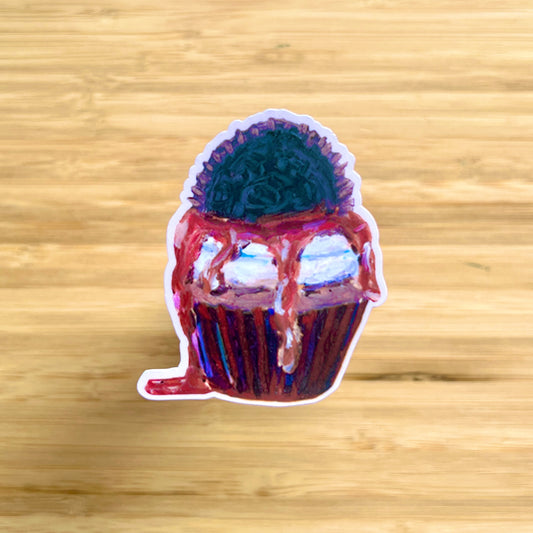 Sticker of a cupcake with chocolate frosting on a wooden surface