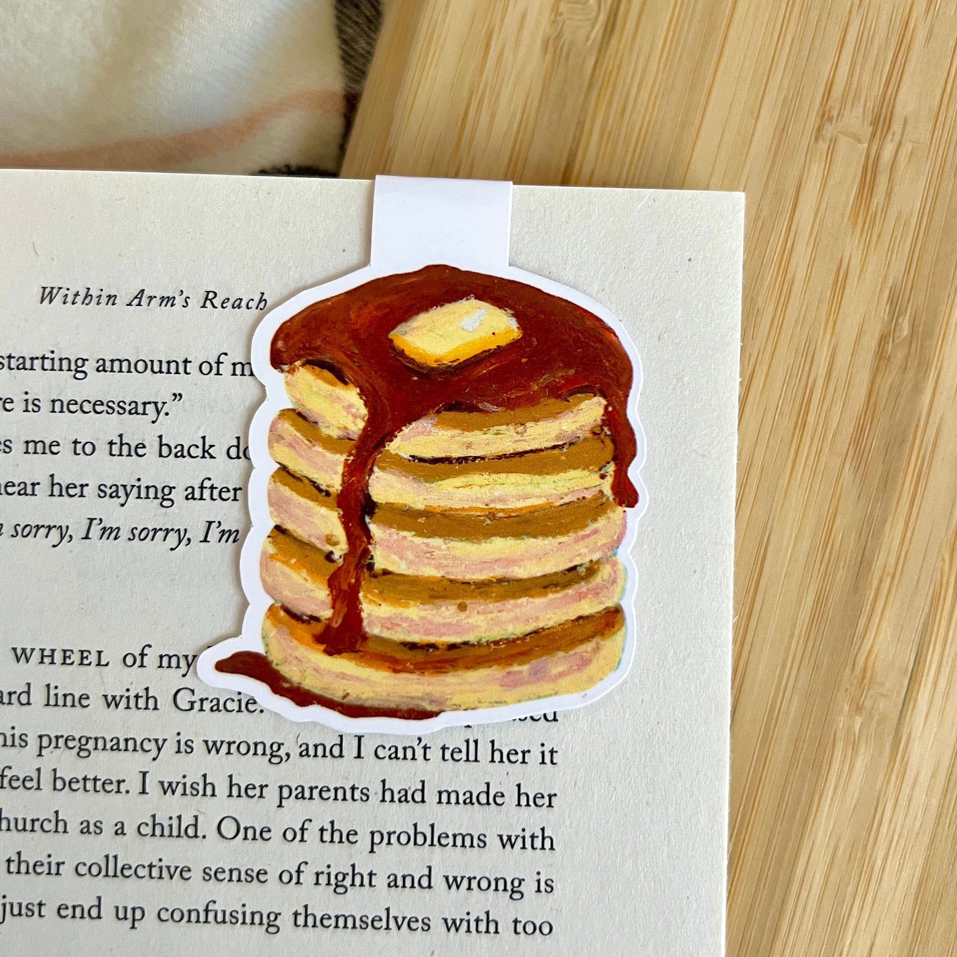 Stack of pancakes with syrup and butter on a book page