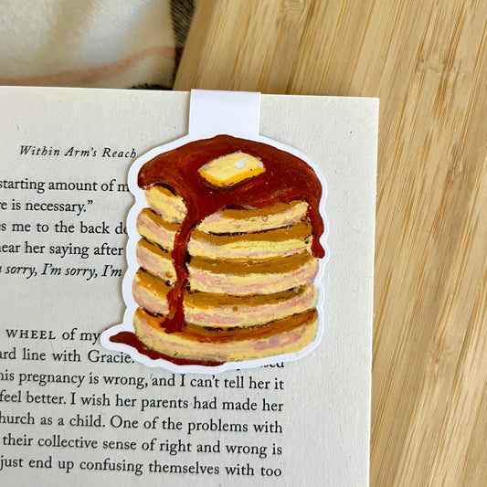 Stack of pancakes with syrup and butter on a book page