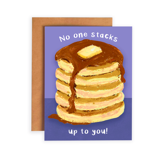 Card with a stack of pancakes and chocolate syrup on a purple background, with a brown envelope.