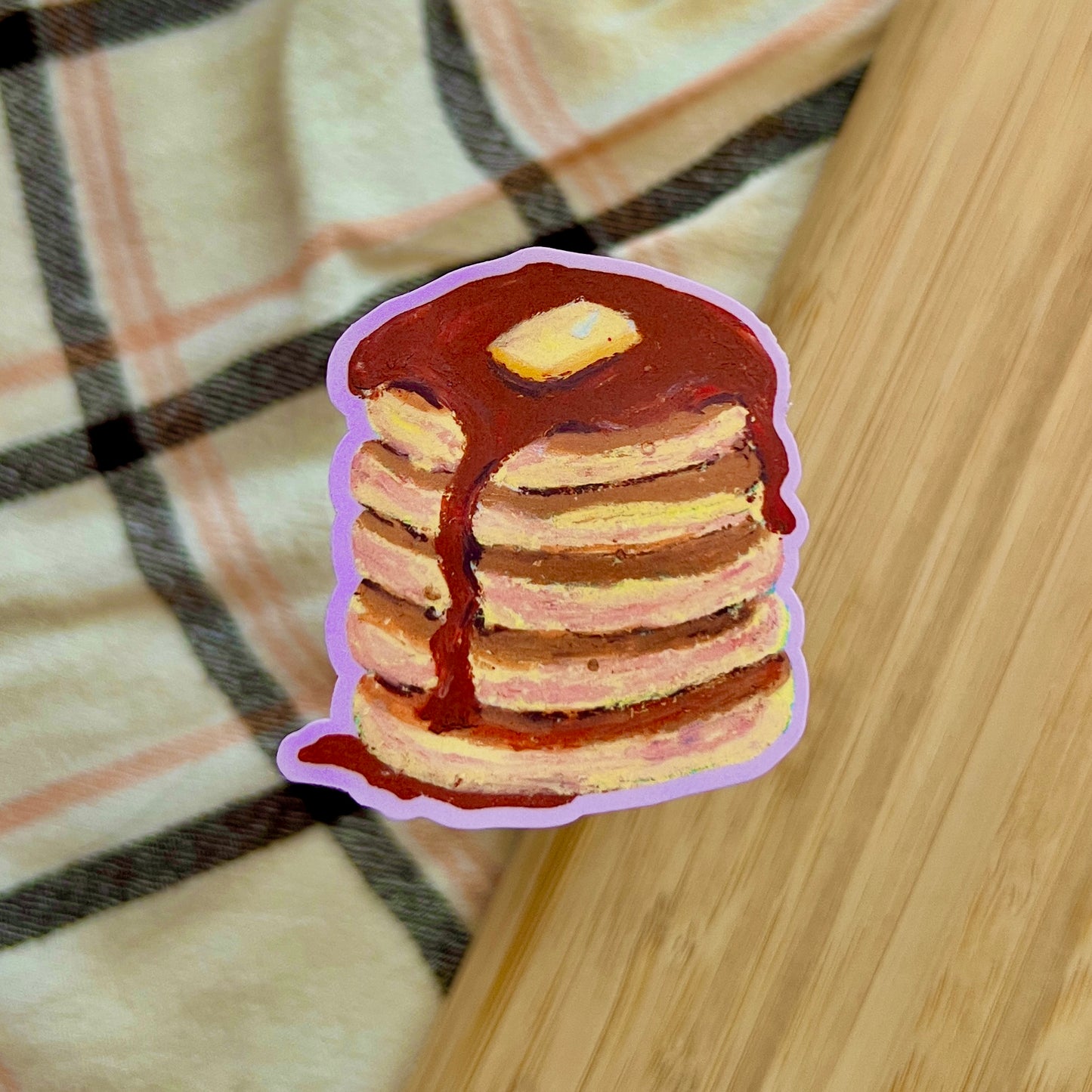 Stack of pancakes with syrup on a wooden surface
