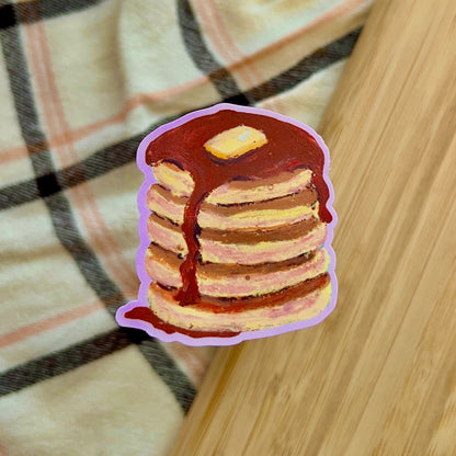 Stack of pancakes with syrup on a wooden surface