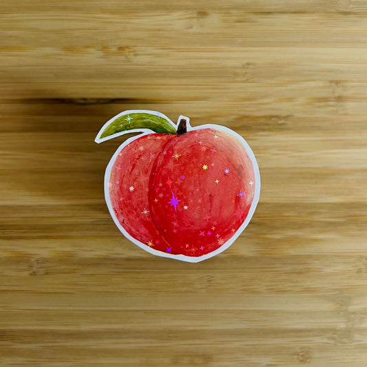 Sticker of a peach with decorative elements on a wooden surface