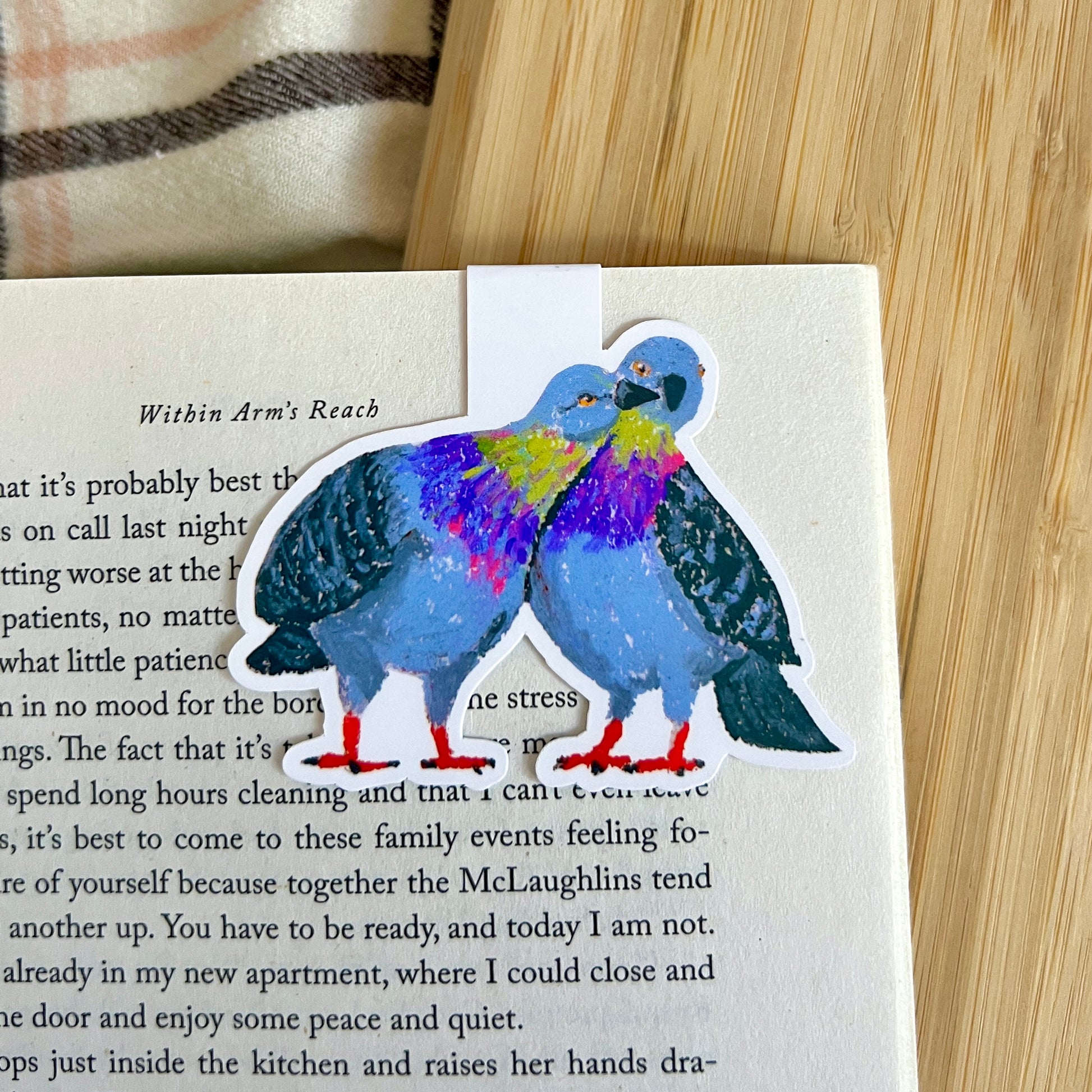 Colorful pigeon illustration on a book page with a wooden surface in the background