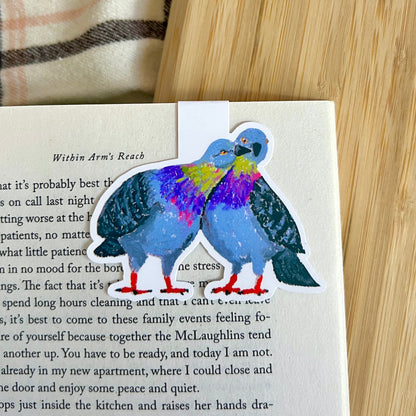 Colorful pigeon illustration on a book page with a wooden surface in the background