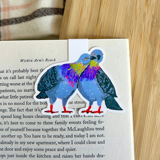 Colorful pigeon illustration on a book page with a wooden surface in the background