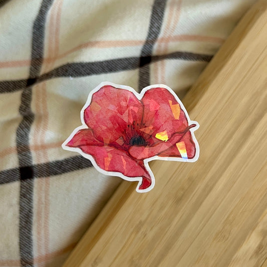 Red flower-shaped sticker on a plaid fabric background