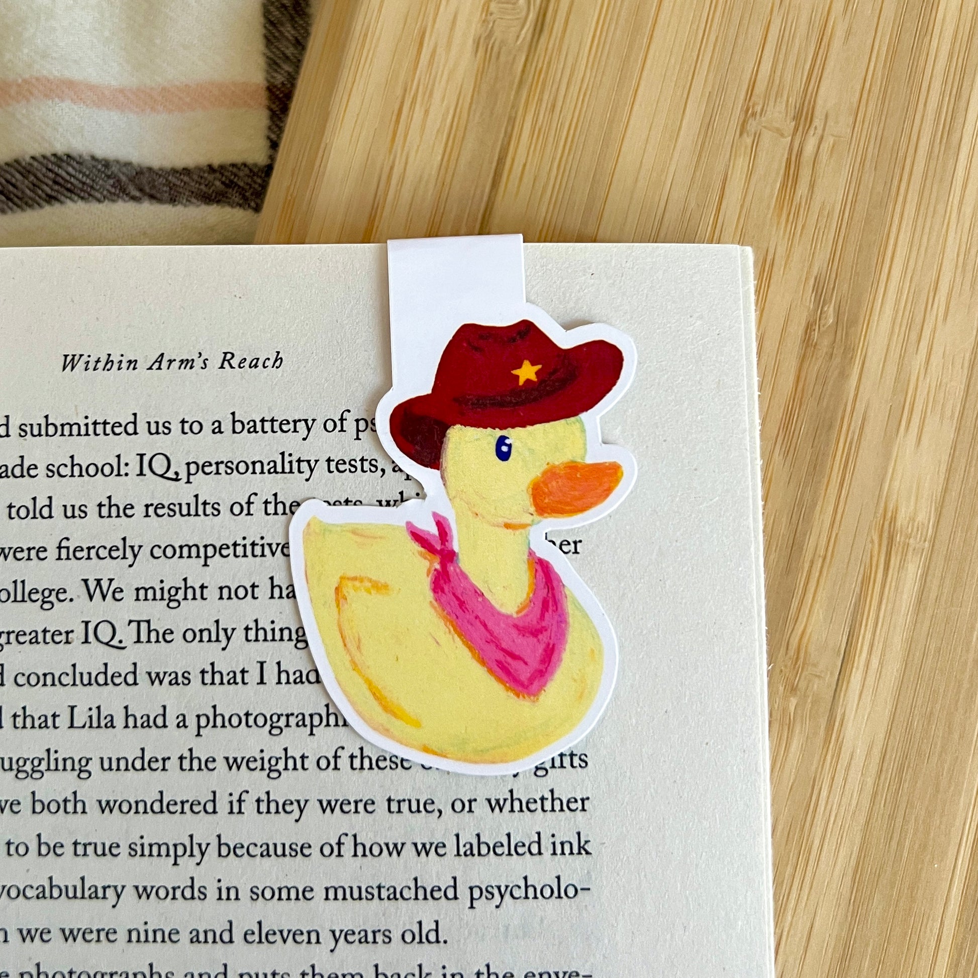 Bookmark with a duck wearing a cowboy hat on a book