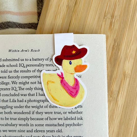 Bookmark with a duck wearing a cowboy hat on a book